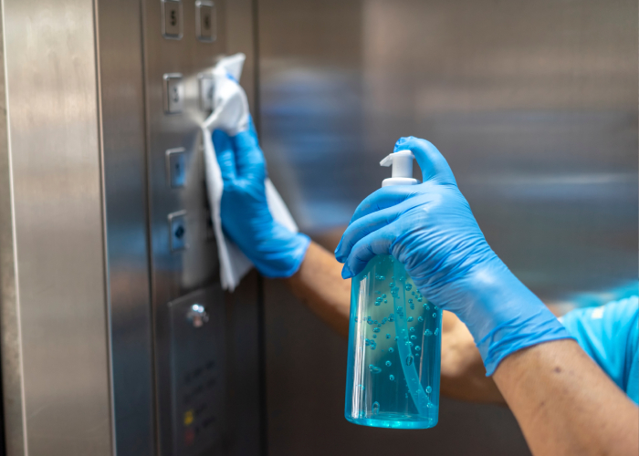 A person cleaning the elevator buttons