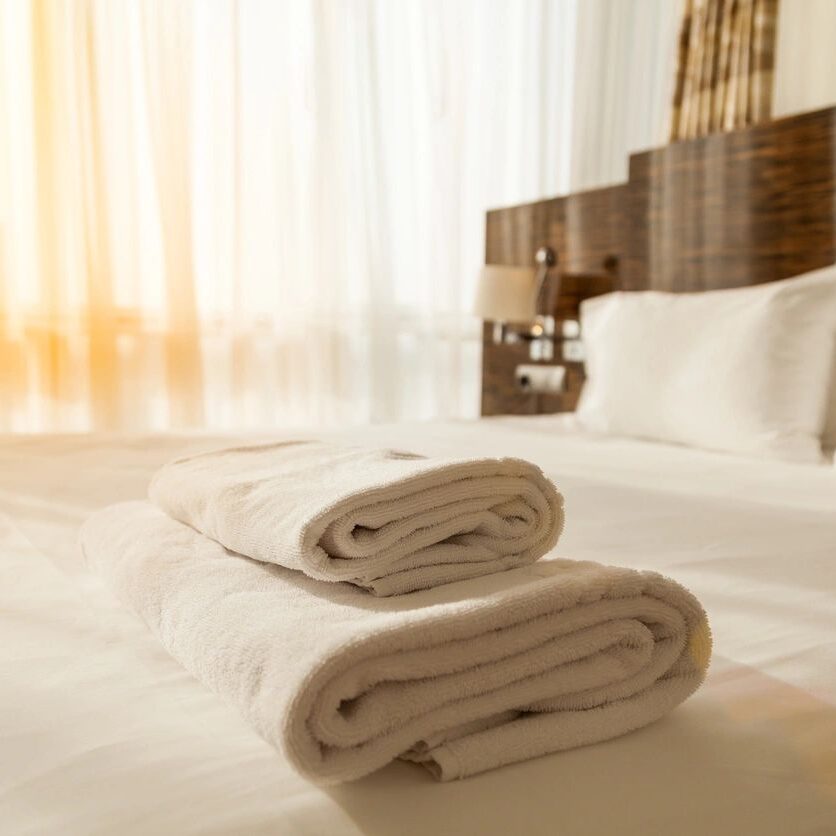 Two rolled towel on a bed